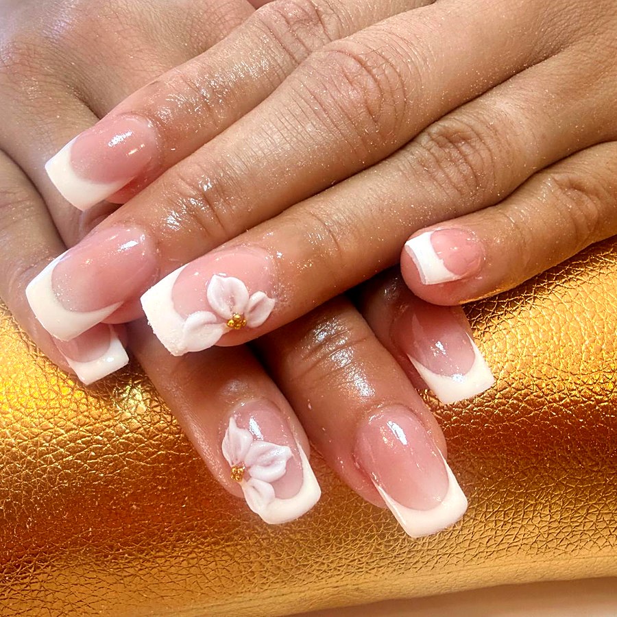 Manicura francesa blanca con flor tridimensional